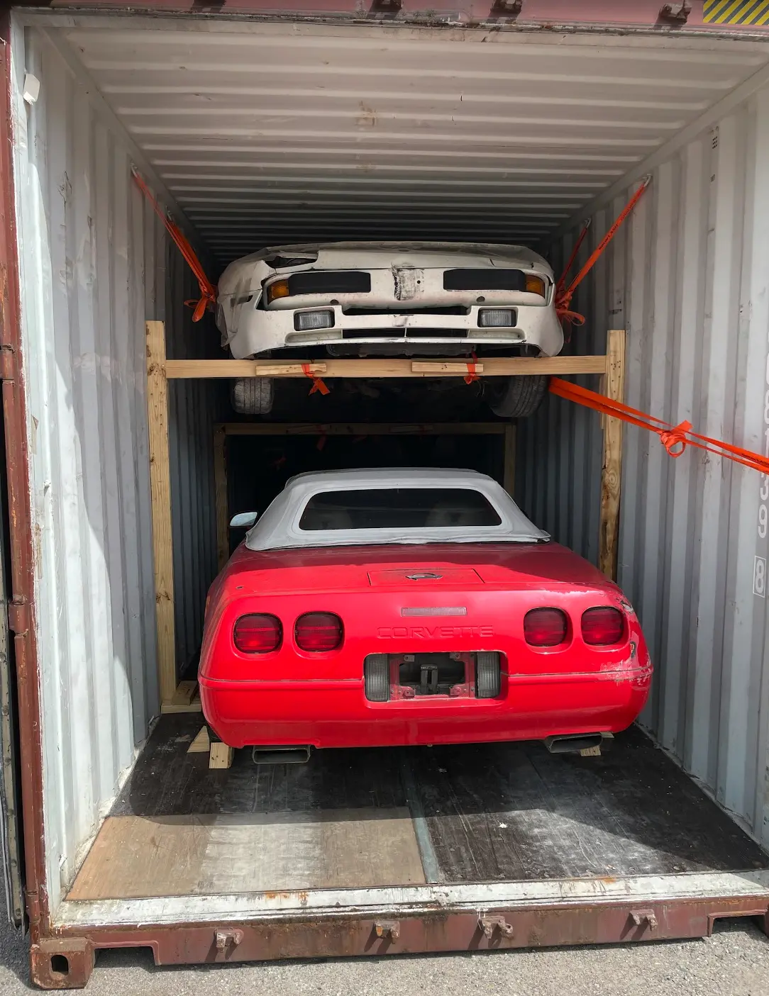 Two cars strapped inside a shipping container for cross-border transport